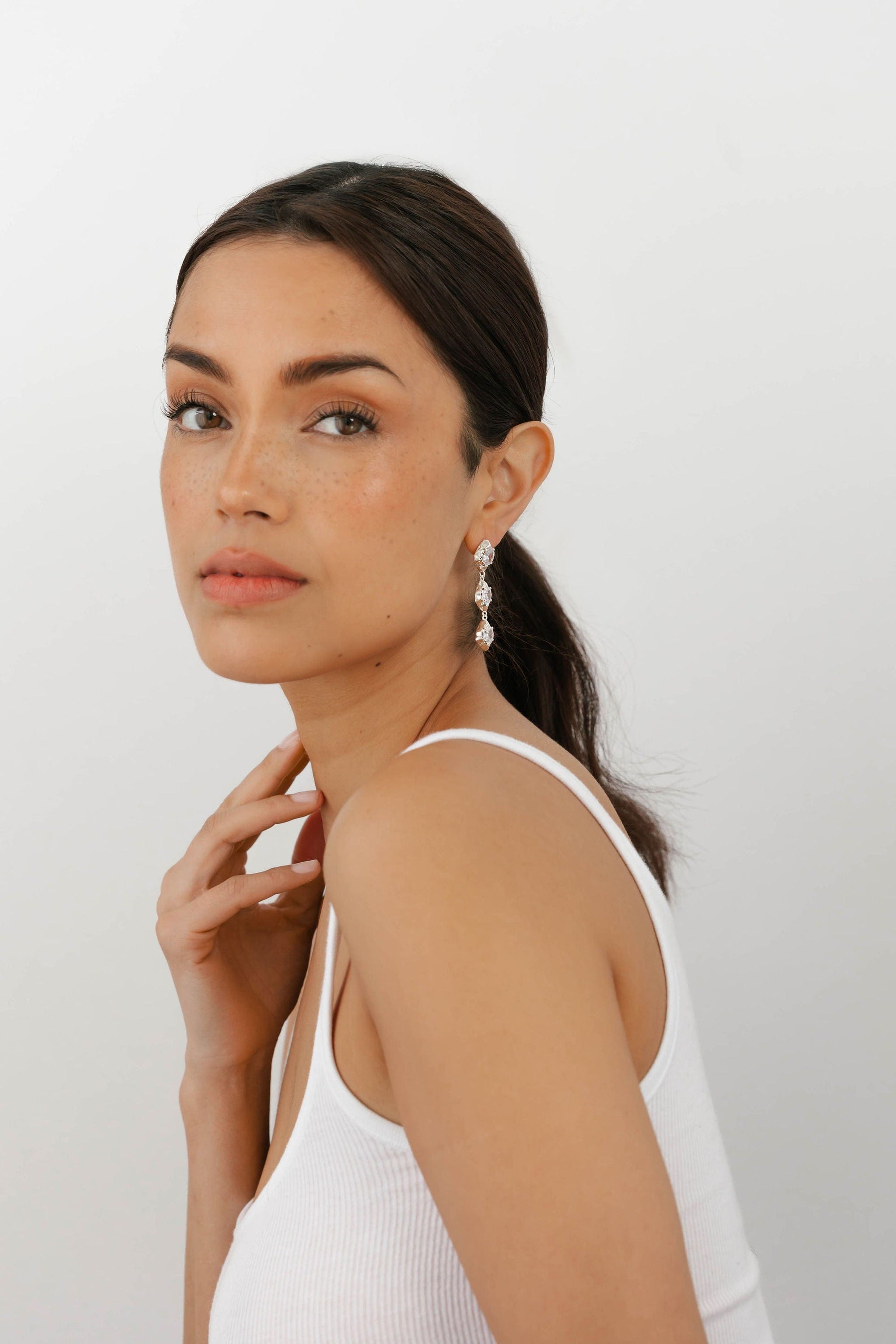 The Perfect Hoop Aura Drop Hoop in silver, styled on a model, showcasing the elegant silver drop silhouette with a soft reflective finish.
