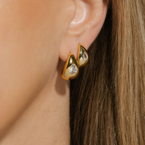 The Amadora Hoop Duo | Crystal – stacked 18K gold-plated sculptural hoops featuring pear-shaped crystal accents, worn on model for a bold and brilliant layered ear look, by The Perfect Hoop.