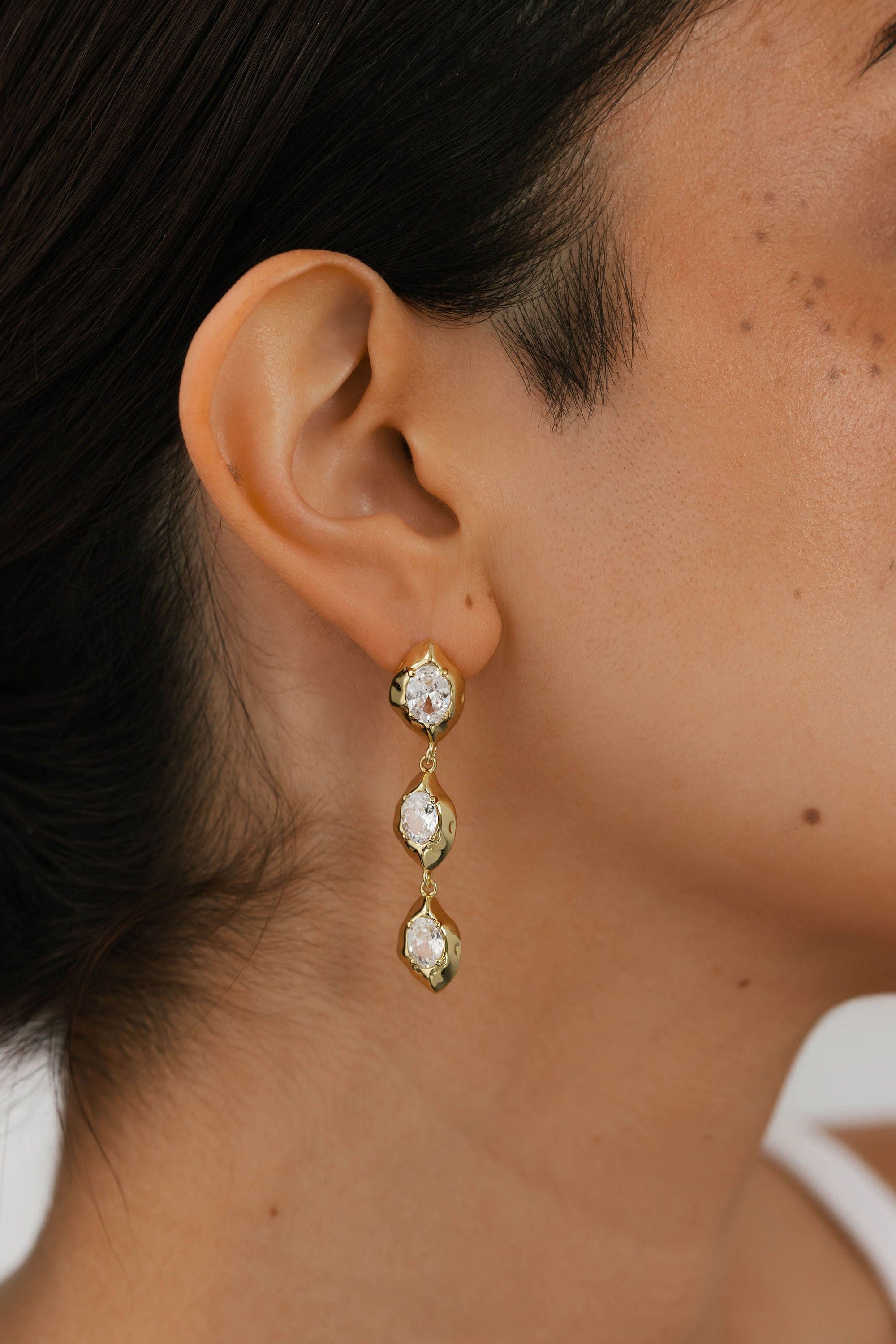 The Perfect Hoop zoomed-in view of The Aura Drop Hoop in gold with double crystal detail, highlighting the faceted sparkle and unique organic gold setting.